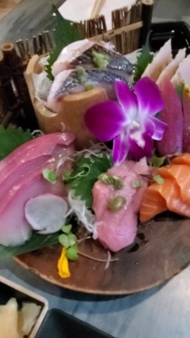 Plated sashimi beside small dishes.